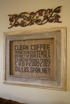 a cross stitch pattern hanging on the wall next to a framed sign that reads clean coffee