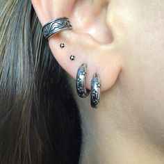 a close up of a person's ear with two piercings on it and one behind the ear