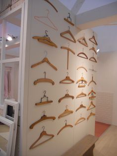 there are many wooden clothes hangers on the wall