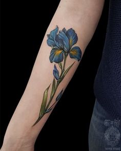 a blue flower tattoo on the left arm