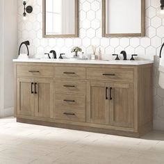 a bathroom vanity with two sinks and mirrors