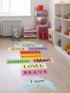 a child's playroom with wooden flooring and colorful words on the floor