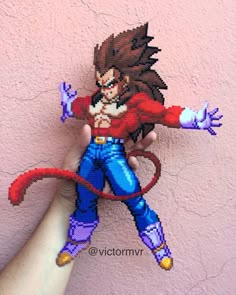 a hand holding up a pixellated image of gohan from the video game dragon ball