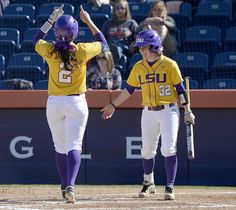 two softball players are walking off the field after being called out to play in a game