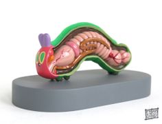 a small figurine of a worm on a white background