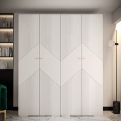 a room with two white doors and a green chair next to it in front of a bookshelf