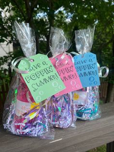 two plastic bags filled with candy and confetti on top of a wooden table