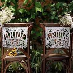 two wooden chairs decorated with flowers and the words bride and groom are sitting side by side