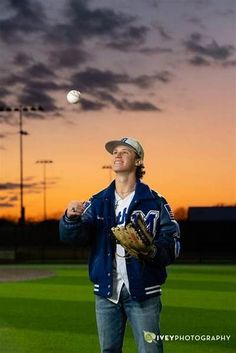 a baseball player throwing a ball at the sunset on a field with his glove in hand