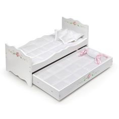 a white doll bed with pink bows on it