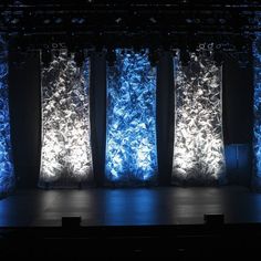 an empty stage with blue lights and curtains