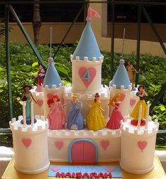 a birthday cake with princess figures on it