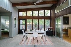 a dining room table with four chairs and a rug on the floor in front of it