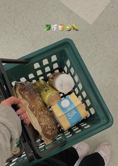 a person holding a shopping basket full of food