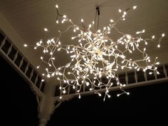 a chandelier with white lights hanging from it's ceiling