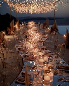 a long table is set with candles and place settings for an outdoor dinner or party