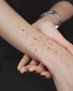 two people holding each other's hands with tattoos on their arms and wristes