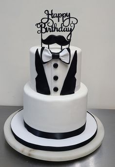 a birthday cake with a tuxedo and bow tie on it's top