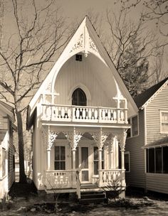 a black and white photo of a small house with an arched window on the front