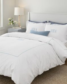 a white bed with blue trim and pillows