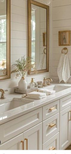 a white bathroom with two sinks and mirrors