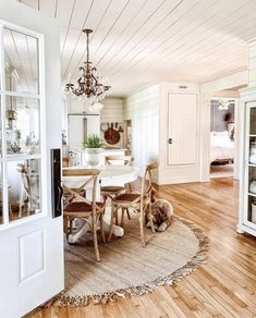 a dining room table with chairs and a rug on the floor