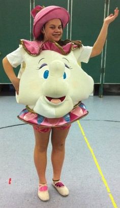 a girl in a costume is holding an elephant head