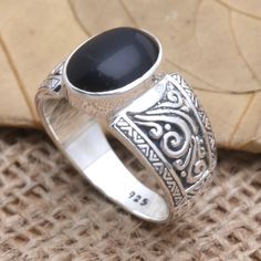 A jet black gem commands attention at the center of Made Mustika's stunning cocktail ring. The Balinese artisan crafts the ring from a smooth onyx stone in a sterling silver bezel setting engraving the ring's sterling silver band with fascinating oxidized designs. Black Oval Cabochon Jewelry For Anniversary, Black Cabochon Ring As A Gift, Black Cabochon Ring For Gift, Elegant Black Jewelry With Large Stone, Black Round Jewelry With Large Stone, Black Sterling Silver Jewelry With Oval Cabochon, Black Jewelry With Large Round Stone, Black Ring With Stone Setting, Silver Onyx Cabochon Rings