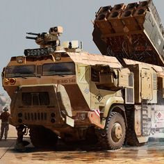 an army truck with two men standing next to it and another vehicle in the background