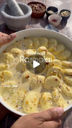 a bowl filled with food sitting on top of a table next to bowls and spoons