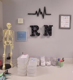 a skeleton is standing in the corner of an office desk with medical supplies on it