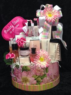 a gift basket filled with lots of beauty products and flowers on top of a black background