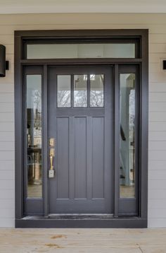 a gray front door on a white house