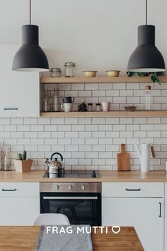 the kitchen is clean and ready to be used for cooking or baking, with two hanging lights above the stove