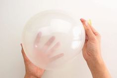 a person holding a large white bubble ball in their right hand with both hands on it