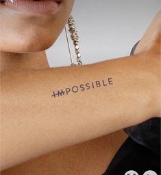 a woman's arm with the word impossible written on it and an embosible tattoo