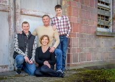 a family posing for a photo in front of an old building with the door open