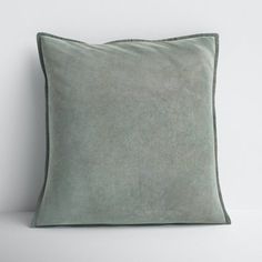 a green pillow sitting on top of a white table