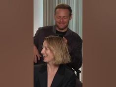 a man is getting his hair cut by a woman in a black suit and tie