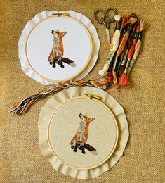 two cross stitch kits with scissors and thread