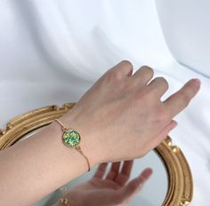 💚 Gold Plated Bracelet with Jade Green Porcelain Flower Disc Embrace the beauty and tradition of ancient Chinese art with our exquisite gold plated bracelet. This elegant piece features a round jade green porcelain disc, intricately adorned with delicate floral patterns that showcase the timeless beauty of traditional Chinese design. The rich green hue of the porcelain combined with the intricate floral motifs not only highlights the craftsmanship but also symbolizes luck and prosperity. The go Chinese Bracelet, Green Porcelain, Ancient Chinese Art, Chinese Jewelry, Everyday Bracelet, Gold Plated Bracelet, Chinese Design, Porcelain Flowers, Rich Green