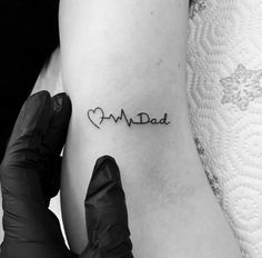 a person with a heartbeat tattoo on their arm and the word dad written in black ink