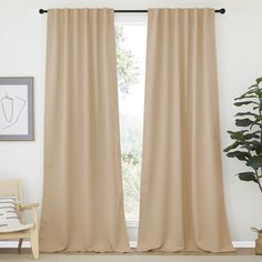 a living room with beige curtains and a chair