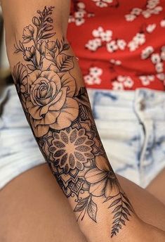 a woman's arm with flowers and leaves tattooed on the side of her body