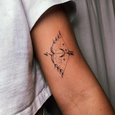 a tattoo on the arm of a person with an arrow and compass in black ink