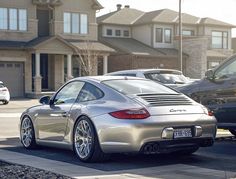 a silver sports car parked in front of some houses