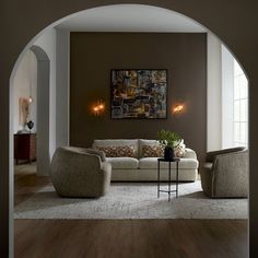 a living room filled with furniture and a painting on the wall