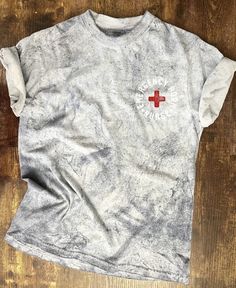 a gray shirt with a red cross on it