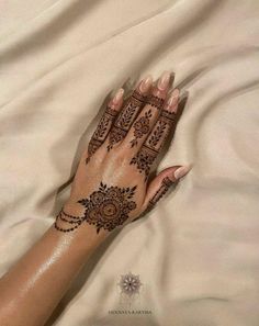 a woman's hand with henna tattoos on it