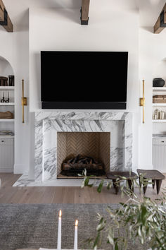 a living room with a fireplace and television above it